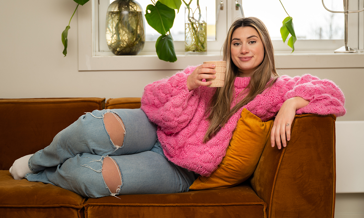 Connie Adelina Lunde ligger på sofan og drikker te. 